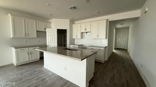 a kitchen with white cabinets and sink