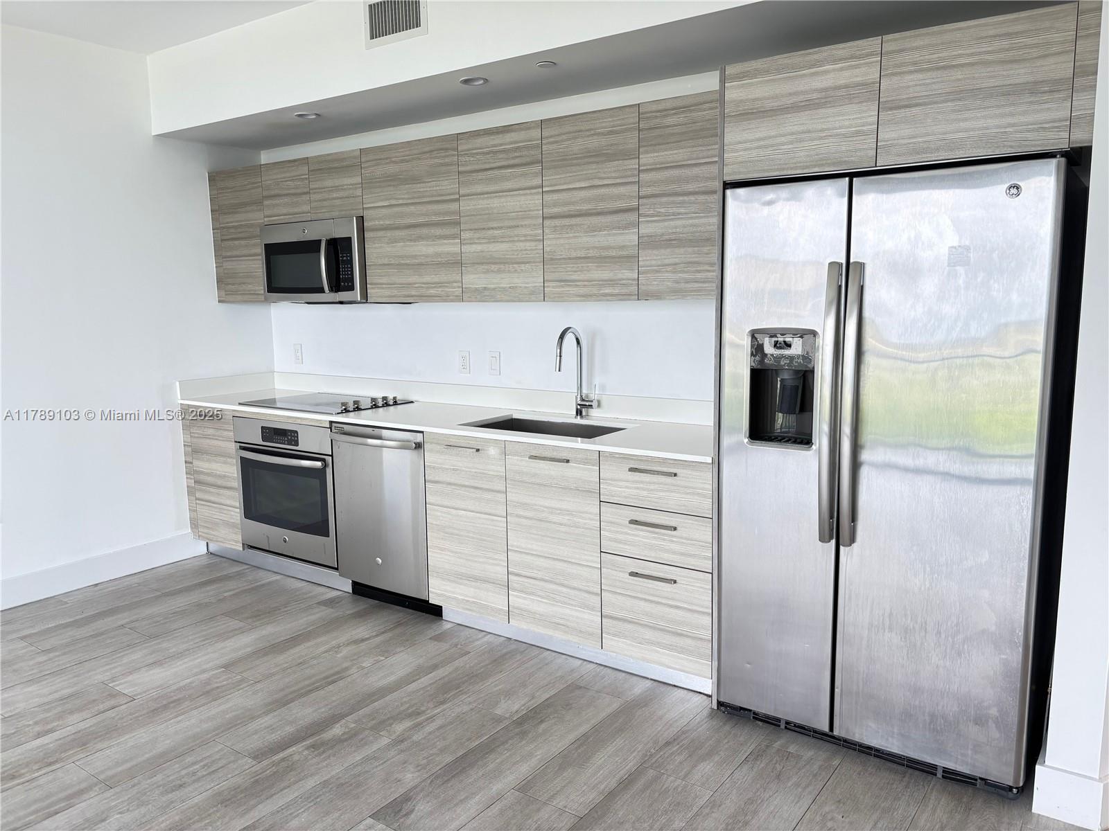 Midtown Miami Miami, FL 33137 - Photo 5 of 28 a kitchen with white cabinets and white appliances