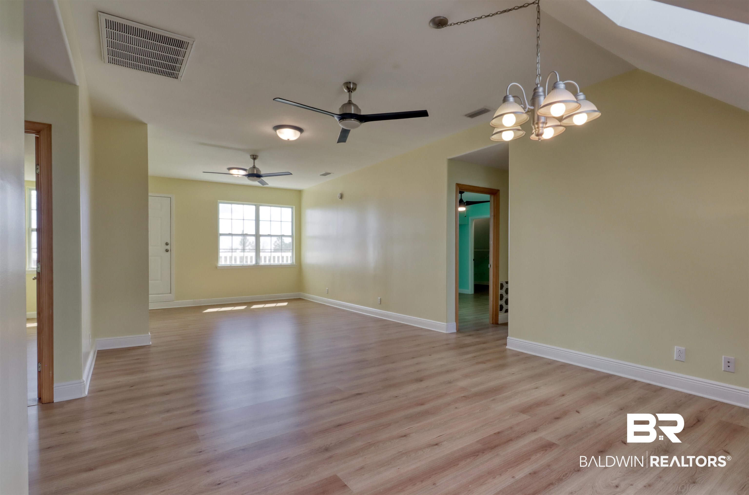 28461 Gardner Road Elberta, AL 36530 - Photo 16 of 46 Spare room featuring a chandelier, light wood-style floors, ceiling fan, and a skylight