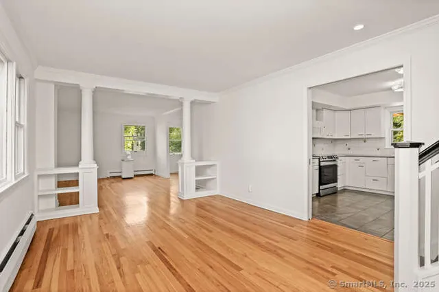 a view of empty room with wooden floor and windows