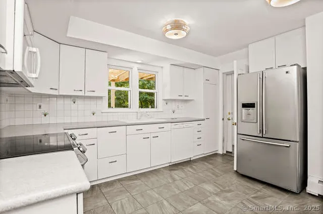 a kitchen with white cabinets and white stainless steel appliances