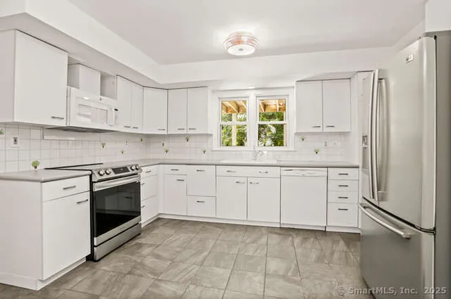 a kitchen with white cabinets and white appliances