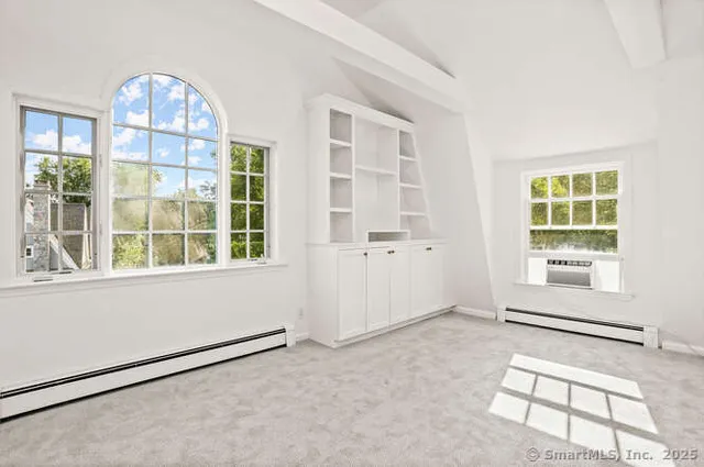 an empty room with windows and glass door