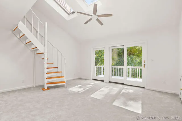 a view of empty room with stairs and fan