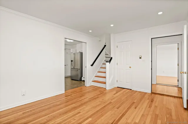 an empty room with wooden floor and entryway