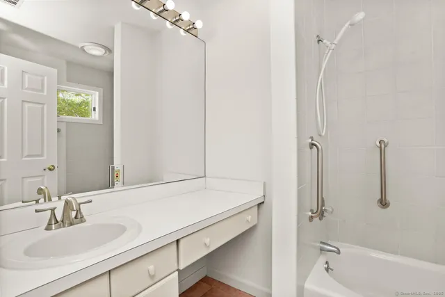 a bathroom with a tub sink and mirror