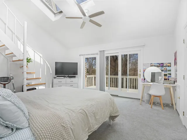 a bedroom with a bed a chair and flat screen tv