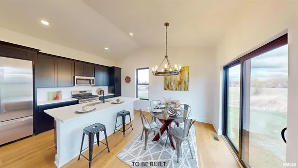 a view of a dining room and livingroom with furniture wooden floor a chandelier