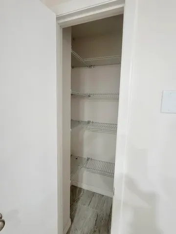 a view of walk in closet with empty racks