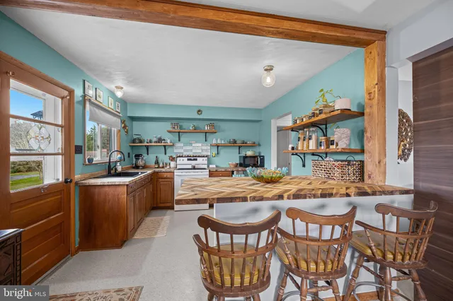 a dining hall with stainless steel appliances granite countertop a stove and a dining table