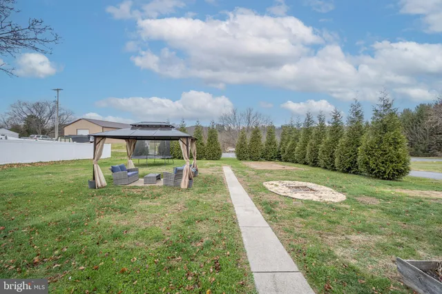 a view of yard with swimming pool and trees in the background