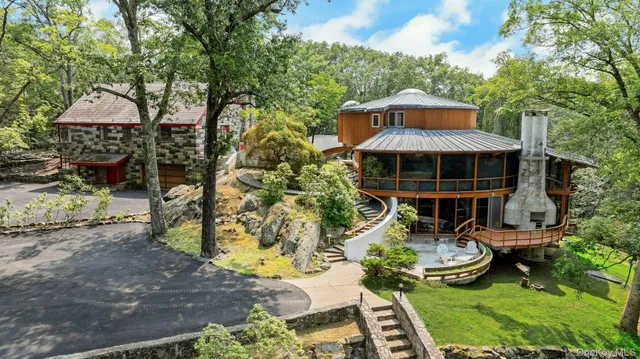 a view of roof deck with table and chairs a barbeque with potted plants and large trees