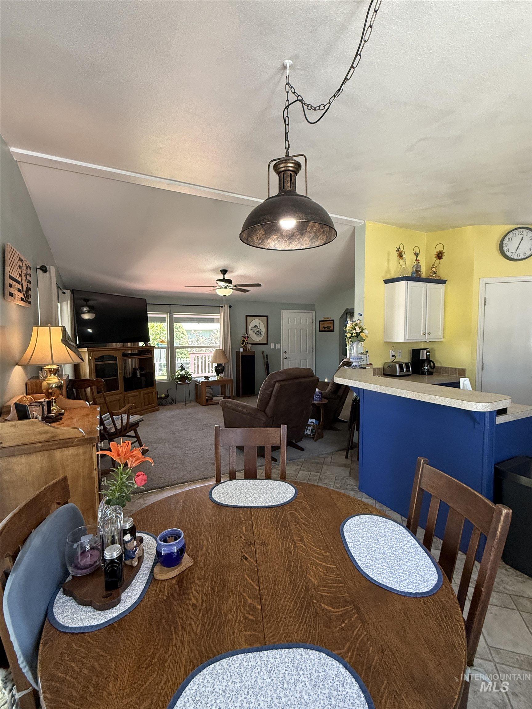 2750 Alden Road, Unit 12 12 Fruitland, ID 83619 - Photo 12 of 38 Open-concept living area featuring a dining space with wood-finish flooring, a contemporary pendant light fixture, and a kitchen counter with a blue base and light-colored countertop