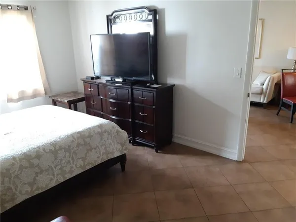 a bedroom with a bed and a flat screen tv