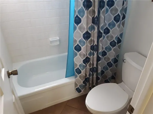 a white toilet sitting next to a bath tub