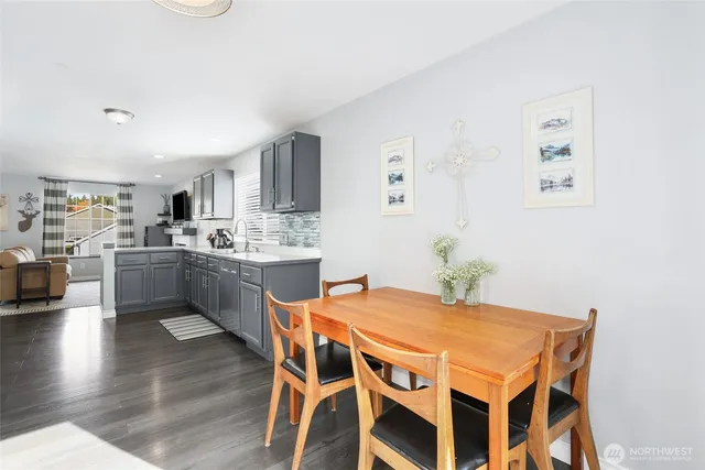 a kitchen with a table chairs a sink dishwasher and cabinets