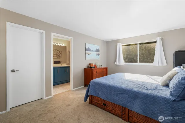 a bedroom with a bed and a dresser next to a window