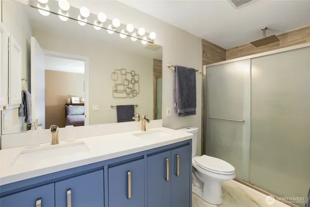 a bathroom with a sink a toilet and large mirror