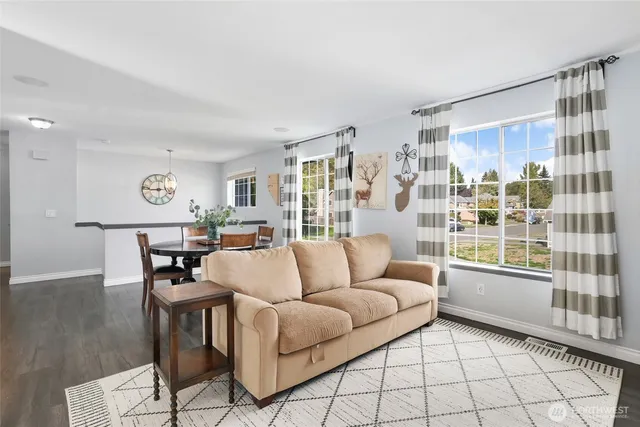 a living room with furniture and a table with wooden floor