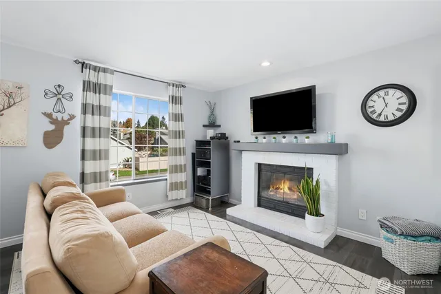 a living room with furniture a flat screen tv and a fireplace