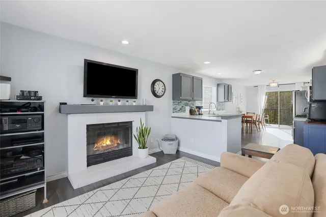 a living room with furniture a flat screen tv and a fireplace
