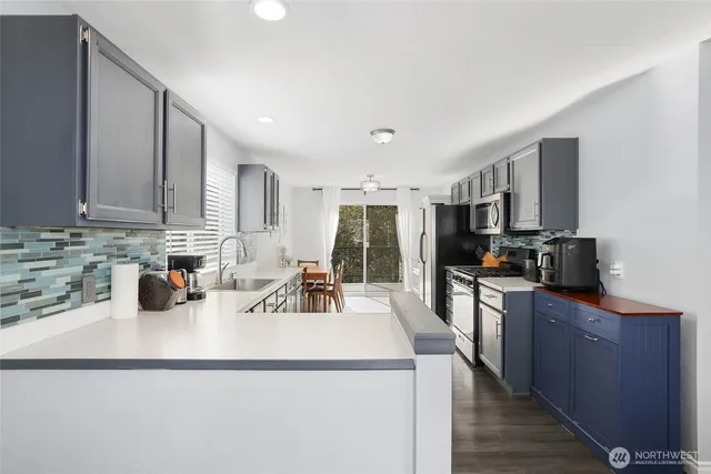 a kitchen with stainless steel appliances a sink a stove a refrigerator cabinets and a counter top space