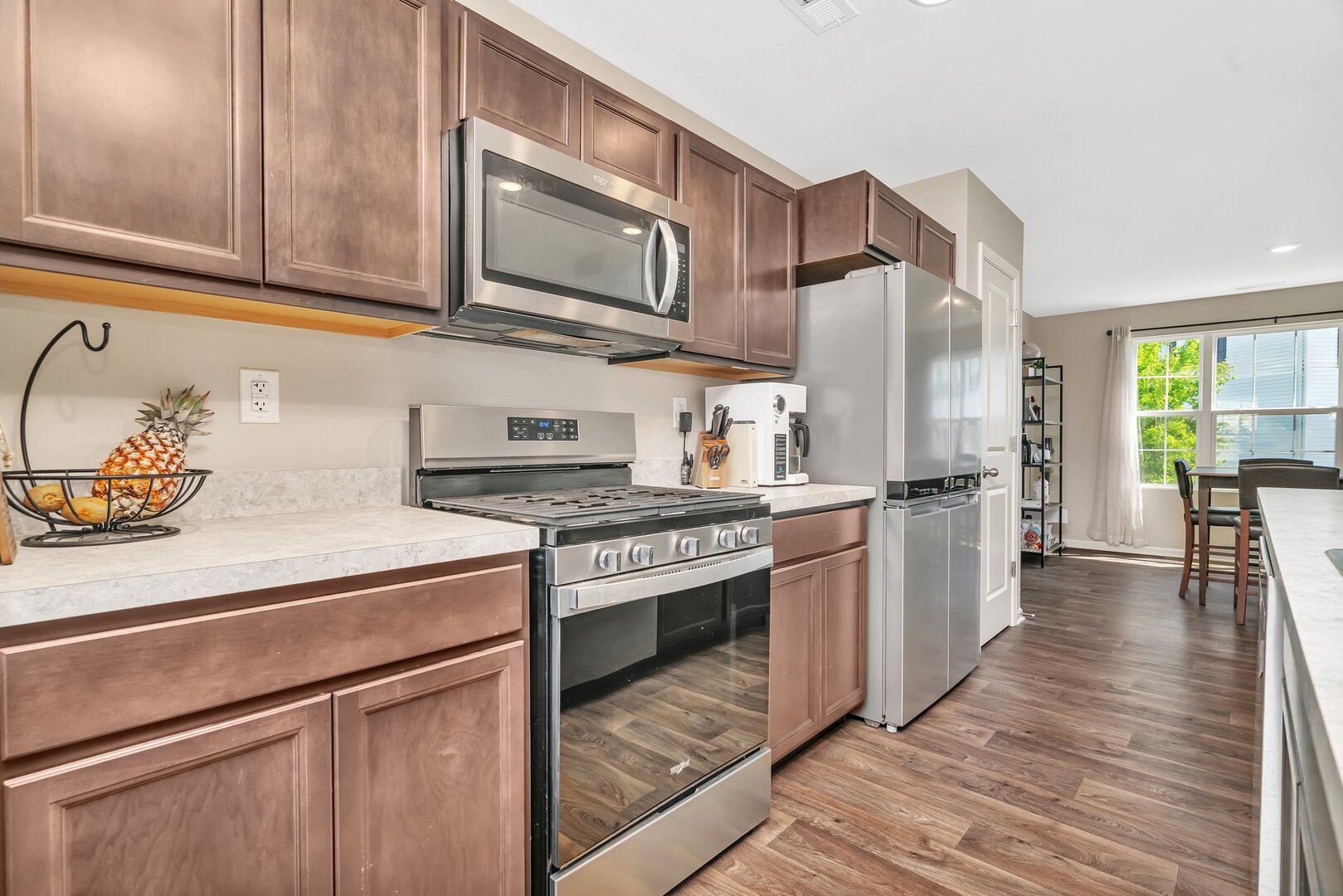 3741 Bailey Road Yorkville, IL 60560 - Photo 12 of 32 a kitchen with stainless steel appliances granite countertop a stove a sink dishwasher and a refrigerator with wooden cabinets