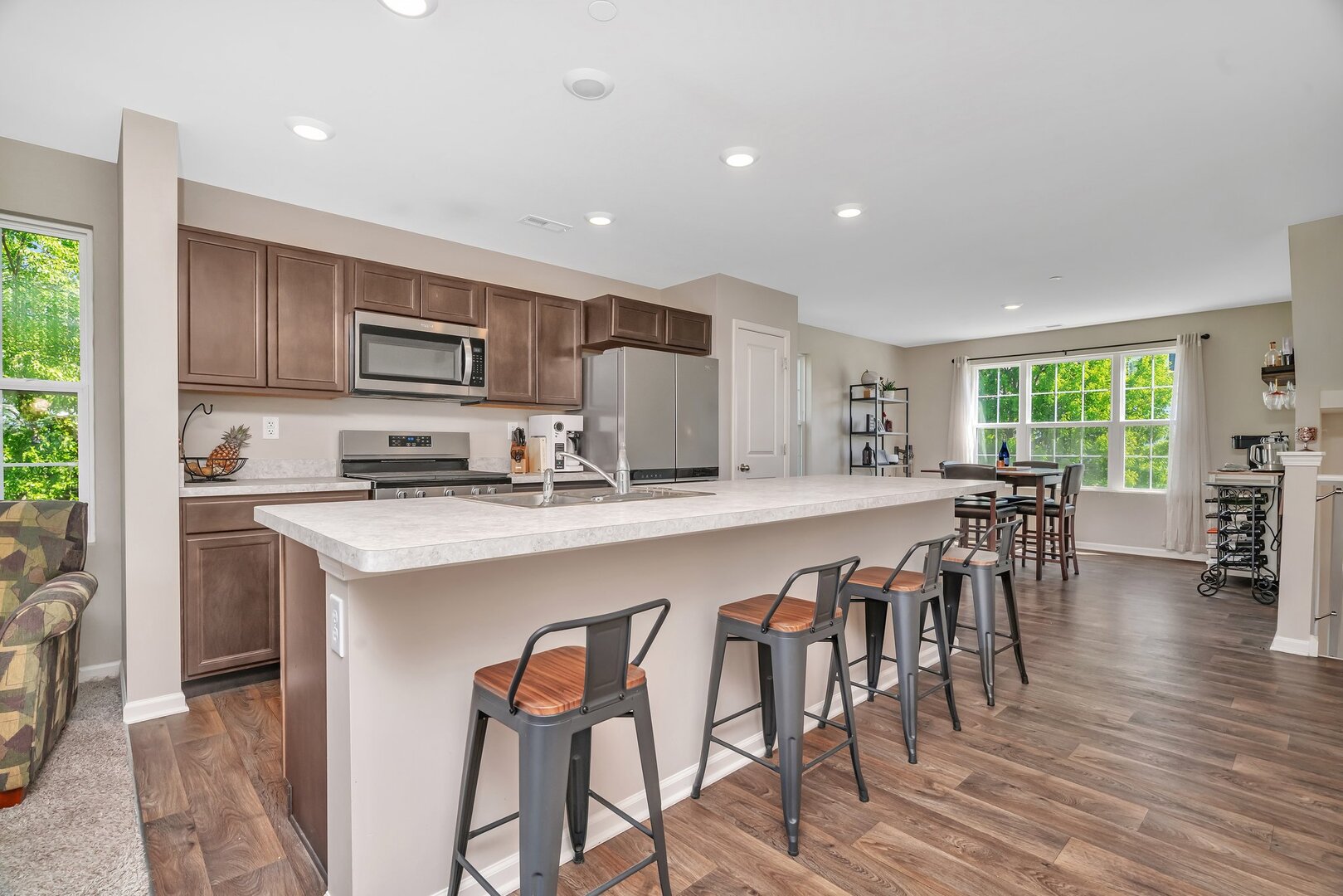 3741 Bailey Road Yorkville, IL 60560 - Photo 8 of 32 a large kitchen with kitchen island a dining table chairs and a wooden floor