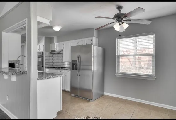 a kitchen with stainless steel appliances kitchen island granite countertop a refrigerator and a sink