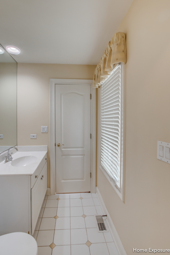2552 Sutton Lane Aurora, IL 60502 - Photo 32 of 57 a bathroom with a sink a toilet and large mirror