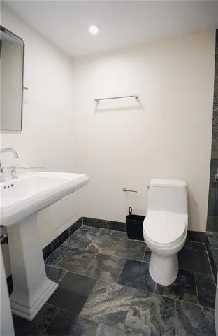 a bathroom with a sink toilet and a mirror