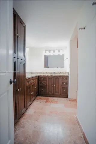 a spacious bathroom with a granite countertop sink a mirror and a bathtub
