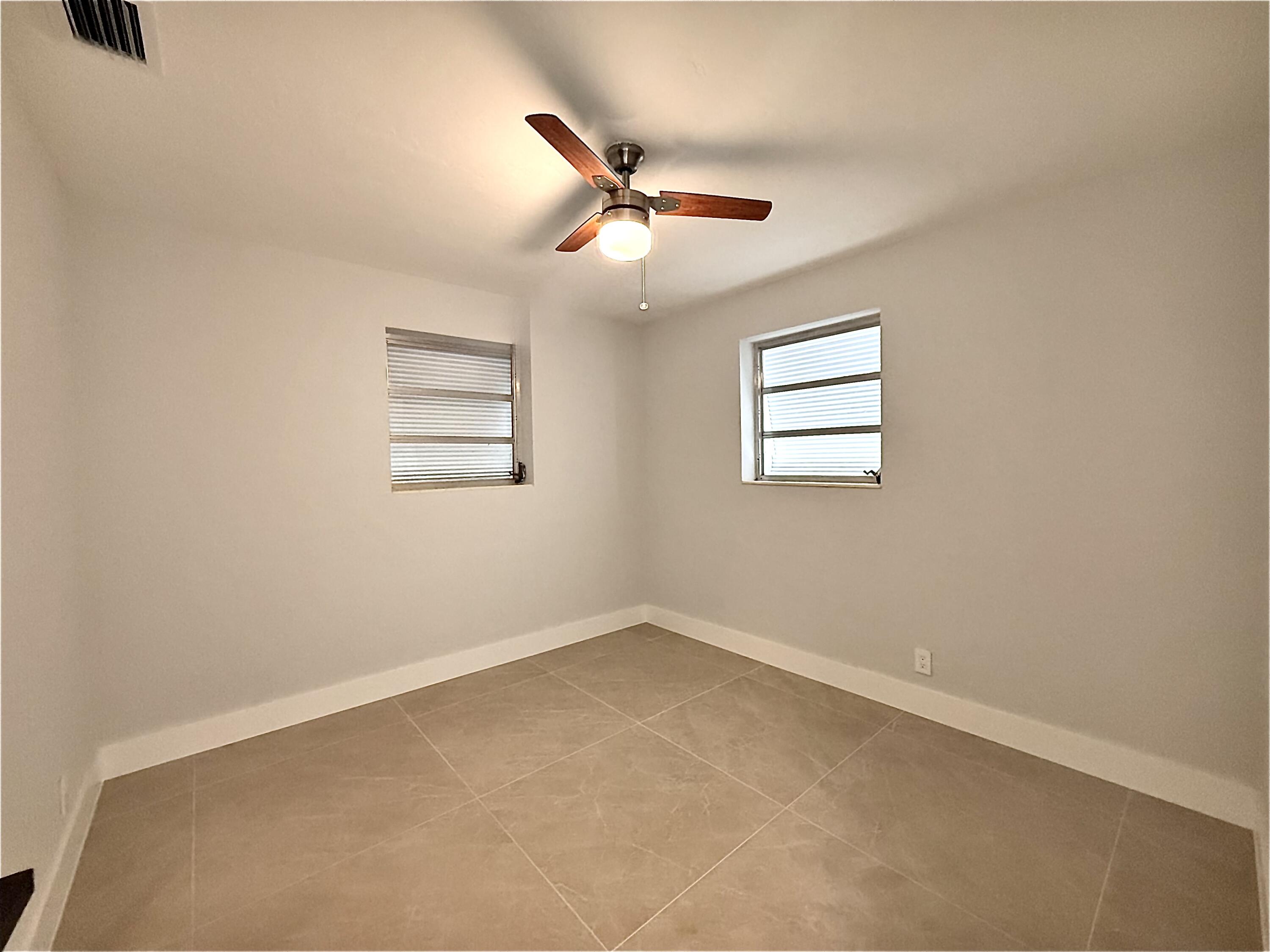 2018 Whitney Road West Palm Beach, FL 33409 - Photo 5 of 11 an empty room with windows and ceiling fan
