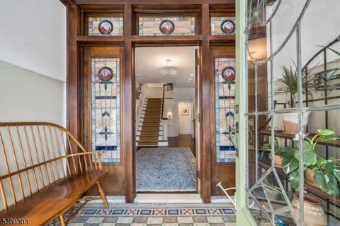 a view of staircase with lots of frames on wall and wooden floor