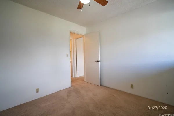 an empty room with chandelier fan