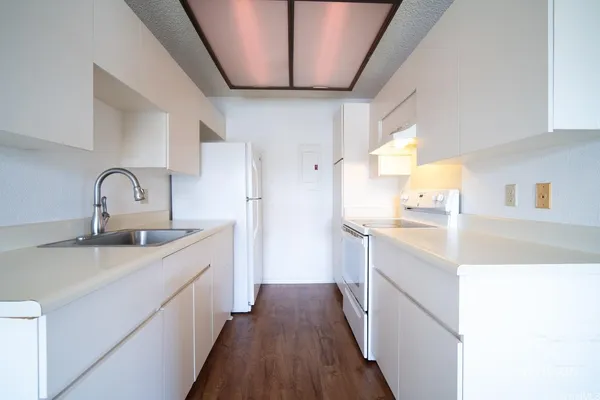 a kitchen with sink a refrigerator and stove