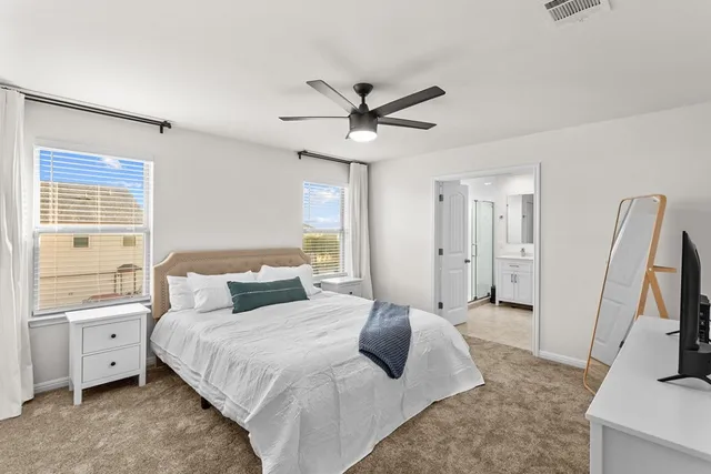 a bedroom with a large bed and a flat tv screen on dresser