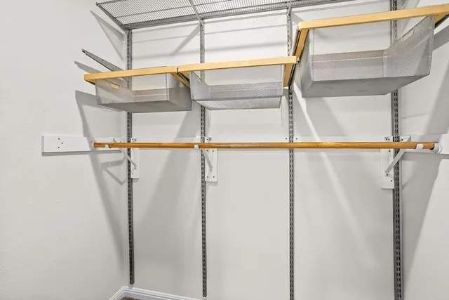 a view of walk in closet with empty racks