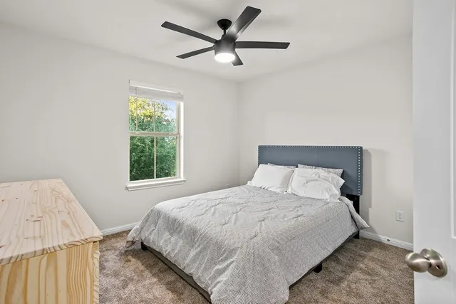 a bedroom with a bed and a large window