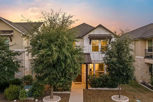 a view of a brick house with a yard and plants