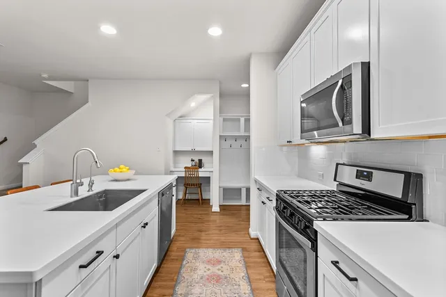 a kitchen with stainless steel appliances granite countertop a sink stove and refrigerator
