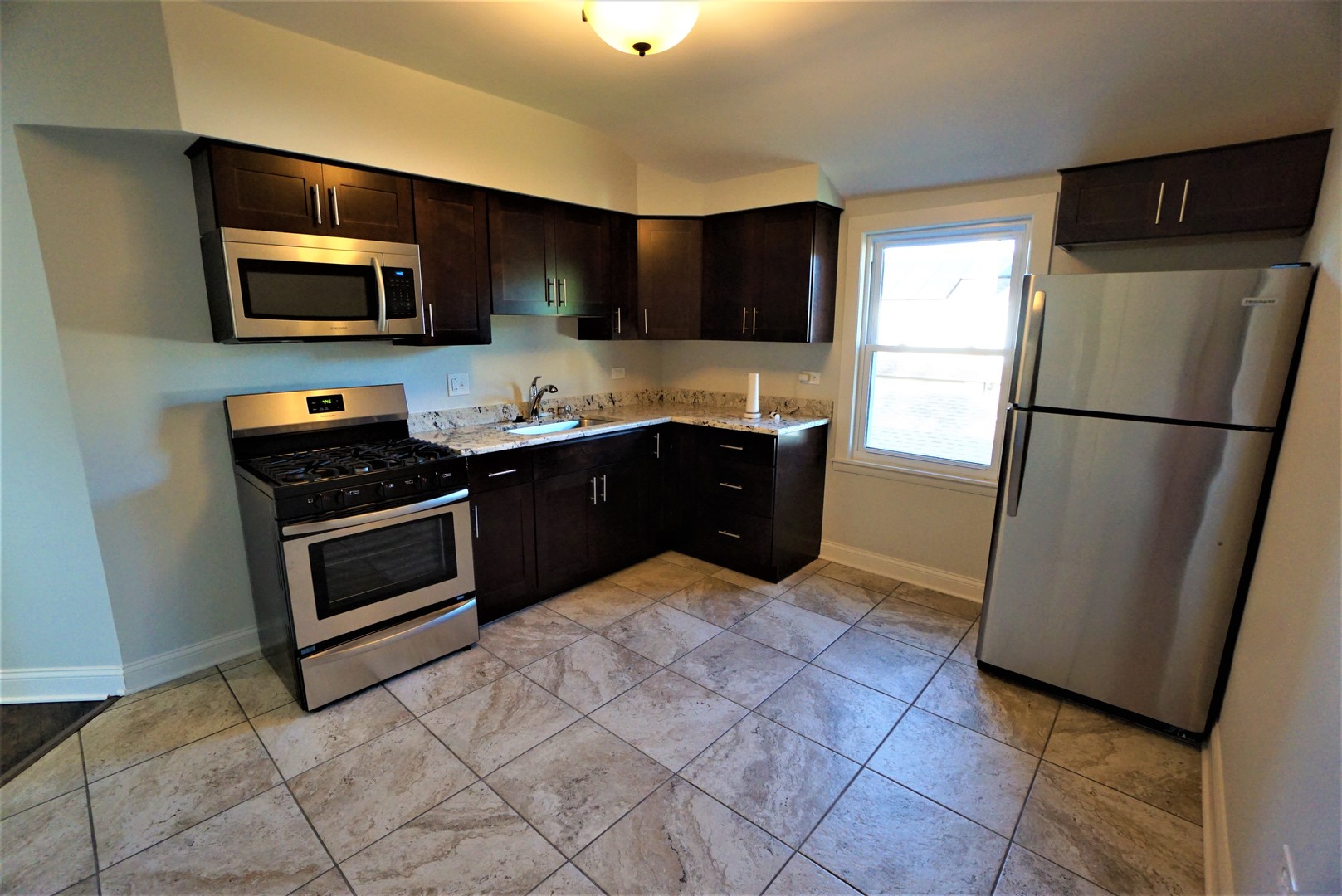 2224 Foster Street Evanston, IL 60201 - Photo 29 of 39 a kitchen with stainless steel appliances a stove a microwave and a refrigerator