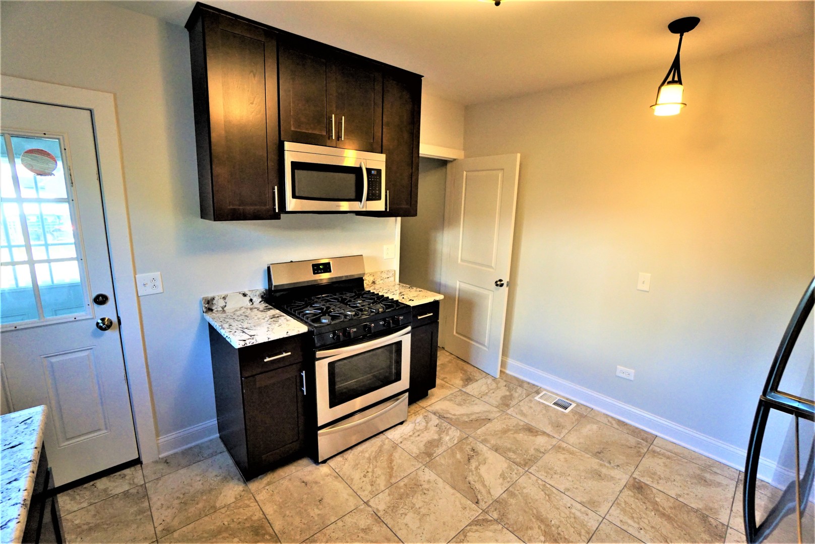2224 Foster Street Evanston, IL 60201 - Photo 10 of 39 a kitchen with stainless steel appliances granite countertop a stove a sink and a refrigerator