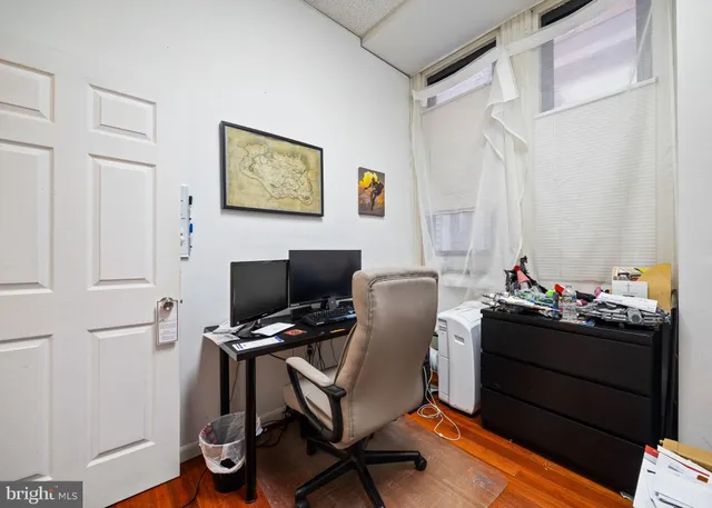 a view of a workspace with furniture and a window