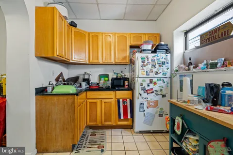 a living room with stainless steel appliances furniture a rug and a window