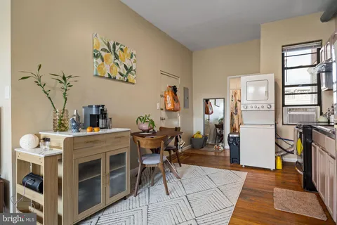 a living room with furniture two large window and a wooden floor