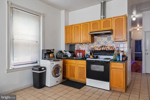 a kitchen with granite countertop a sink cabinets and stainless steel appliances