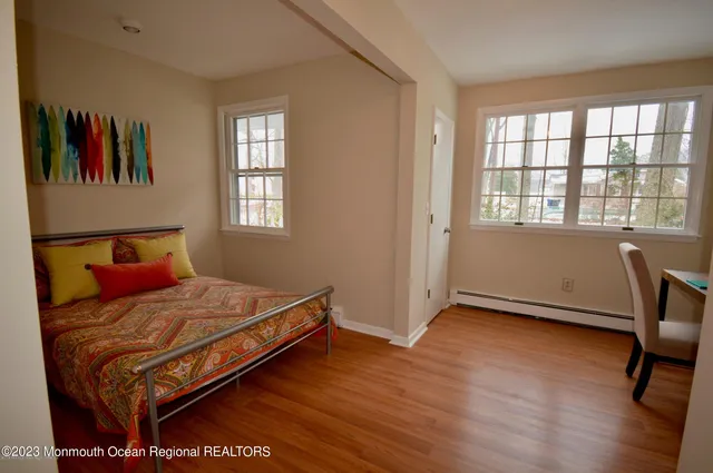 wooden floor in a hall with an entryway and a window