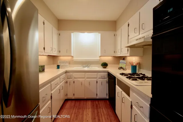 a kitchen with a refrigerator and white cabinets