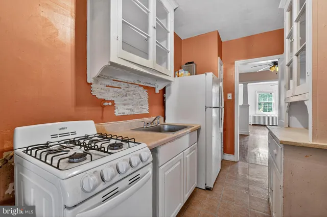 a view of a hallway with wooden floor and a ceiling fan